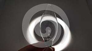 Vintage electric bulb in the shadow against white light circle