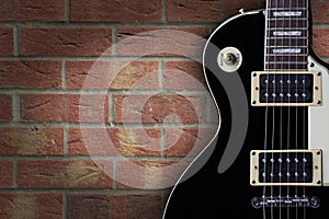 Vintage electric guitar on brick background with copy space