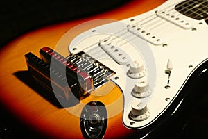 Vintage electric guitar with harmonica on black background