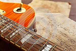 Vintage electric guitar and rare sheet music closeup