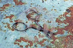 Vintage embroidery scissors on rusty background