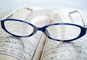 Vintage eyeglasses on old blur Arabic book (Ramadan season)
