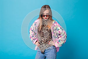 Vintage fashion look concept - pretty young woman wearing a retro jacket and leopard body on blue background