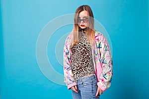 Vintage fashion look concept - pretty young woman wearing a retro jacket and leopard body on blue background with copy