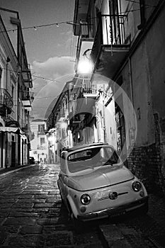 Vintage Fiat 500 car parked in old town of Foggia at night, Puglia, Italy