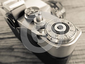 Vintage film camera made in URSS, lying over a dated wooden background photo