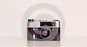 vintage film camera on a table against a white wall close-up