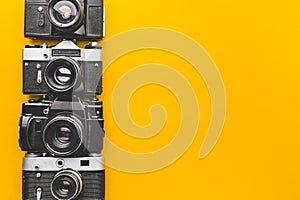 Vintage Film Cameras On Yellow Background Surface. Creativity Retro Technology Concept photo