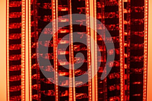 Vintage filmstrip in soft red light. Analog old strips of film for a photo or video camera close up. The concept of