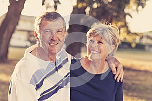 Vintage filter portrait of American senior beautiful and happy mature couple around 70 years old showing love and affection smilin