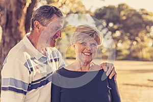 Vintage filter portrait of American senior beautiful and happy mature couple around 70 years old showing love and affection smilin