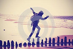 Vintage filtered silhouette of a woman running on wooden posts.