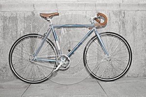 Vintage fixed gear bicycle near concrete wall in city