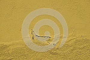 Vintage flakes of old yellow paint over grey concrete wall