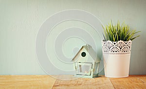 Vintage Flower pot and lantern as a bird house against mint wall and antique lace fabric