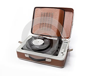 Vintage foldable portable vinyl player with a black sinlge vinyl plate on a turntable