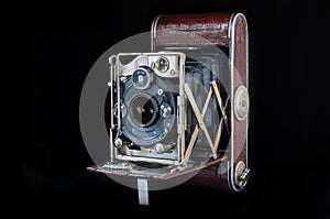Vintage folding camera isolated on the black background