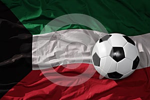 Vintage football ball on the waveing national flag of kuwait background. 3D illustration