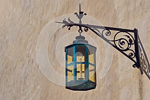 Vintage forged street lamp on wall.