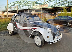 Vintage French popular car Citroen 2CV and old steel bridge