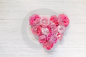 Vintage French rose heart-shaped flowers on white wooden rustic background. Valentine`s day