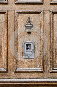 Vintage front wooden door with brass knocker and numlock digit l photo