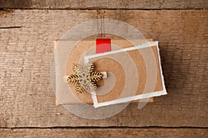 Vintage gift box package with blank gift tag on old wooden background. Christmas festive close up, copy space.