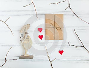Vintage gift and wooden rabbit on white table. Presents for Valentine`s day with tree branches. Top view, flat lay