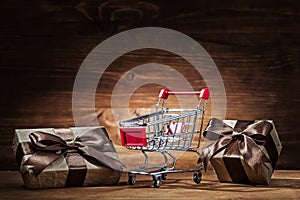 Vintage giftboxes and shopping cart on wood