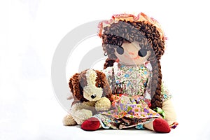 Vintage girl rag doll with her puppy; presented on a plain white background.