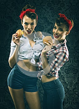 Vintage girlfriends in old style dress eat hamburgers