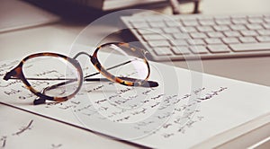 Vintage glasses, notebook and keyboard