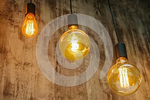Vintage glowing light bulbs. Three hanging retro incandescent lamps