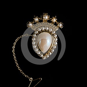 Vintage gold brooch in the shape of a crown with pearls.