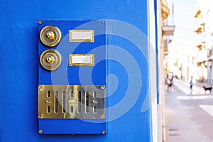 Vintage gold-colored doorbell on the door of apartments with blue facade photo