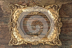 Vintage golden frame on wooden background. Grunge texture