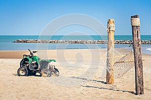 Vintage green ATV on the sandy beach. Quad ATV all terrain vehicle parked on beach, Motor bikes ready for action with summer sun