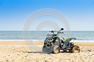 Vintage green ATV on the sandy beach. Quad ATV all terrain vehicle parked on beach, Motor bikes ready for action with summer sun