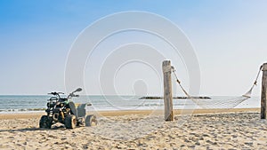 Vintage green ATV on the sandy beach. Quad ATV all terrain vehicle parked on beach, Motor bikes ready for action with summer sun