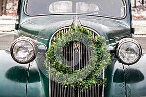 Vintage green classic car adorned with a wreath for Christmas