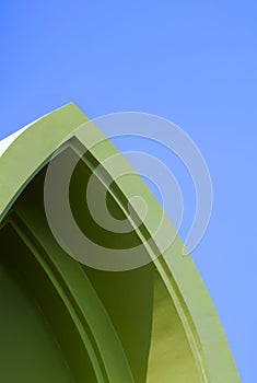 Vintage green gable roof in curved triangle shape against blue sky background