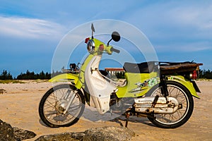 A vintage green motorbike park on the beach