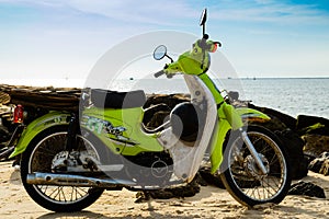 A vintage green motorbike park on the beach, sea background