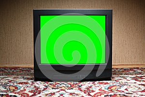 Vintage green screen TV on the floor, old house design in 1980s and 1990s style.