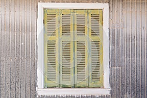 Vintage green shutters on an old corrugated metal wall