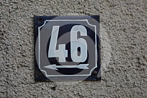 Vintage grunge square metal rusty plate of number of street address with number.