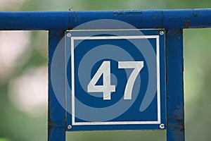 Vintage grunge square metal rusty plate of number of street address with number.