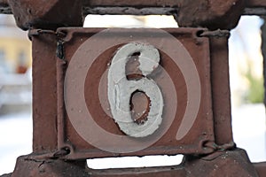 Vintage grunge square metal rusty plate of number of street address with number.