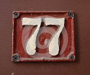 Vintage grunge square metal rusty plate of number of street address with number.