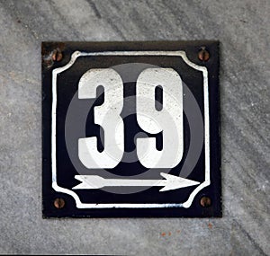 Vintage grunge square metal rusty plate of number of street address with number.